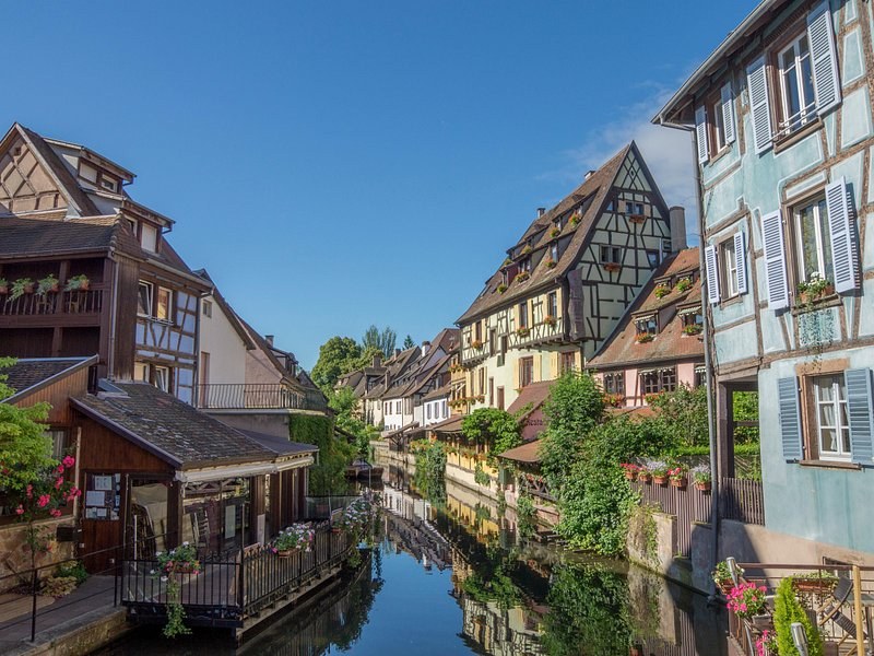 Still water on a Colmar canal, the houses along it doubled in the reflection