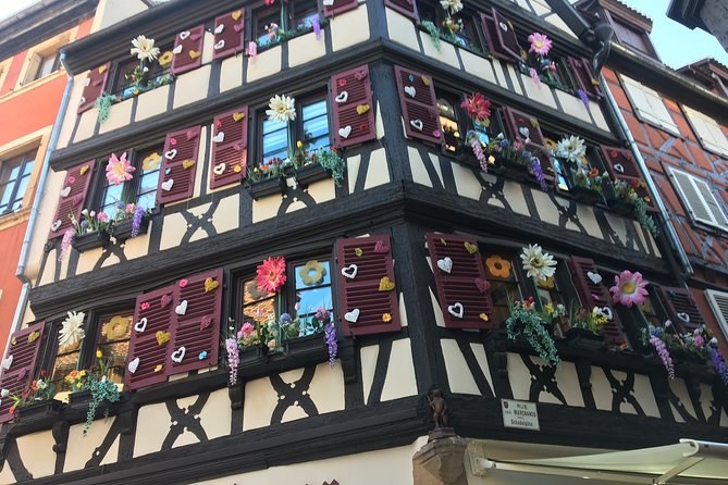 A tall half-timbered front, every window hung with flower boxes in bloom