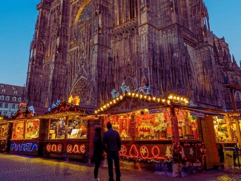 Strasbourg's cathedral front rising over the lit chalets of the Christmas market