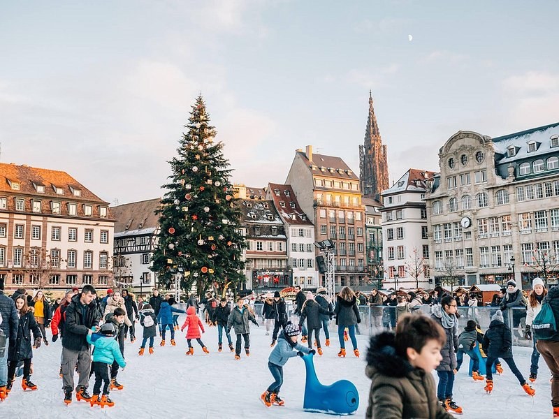 The Christmas tree and the skating rink on a Strasbourg square, the cathedral spire beyond